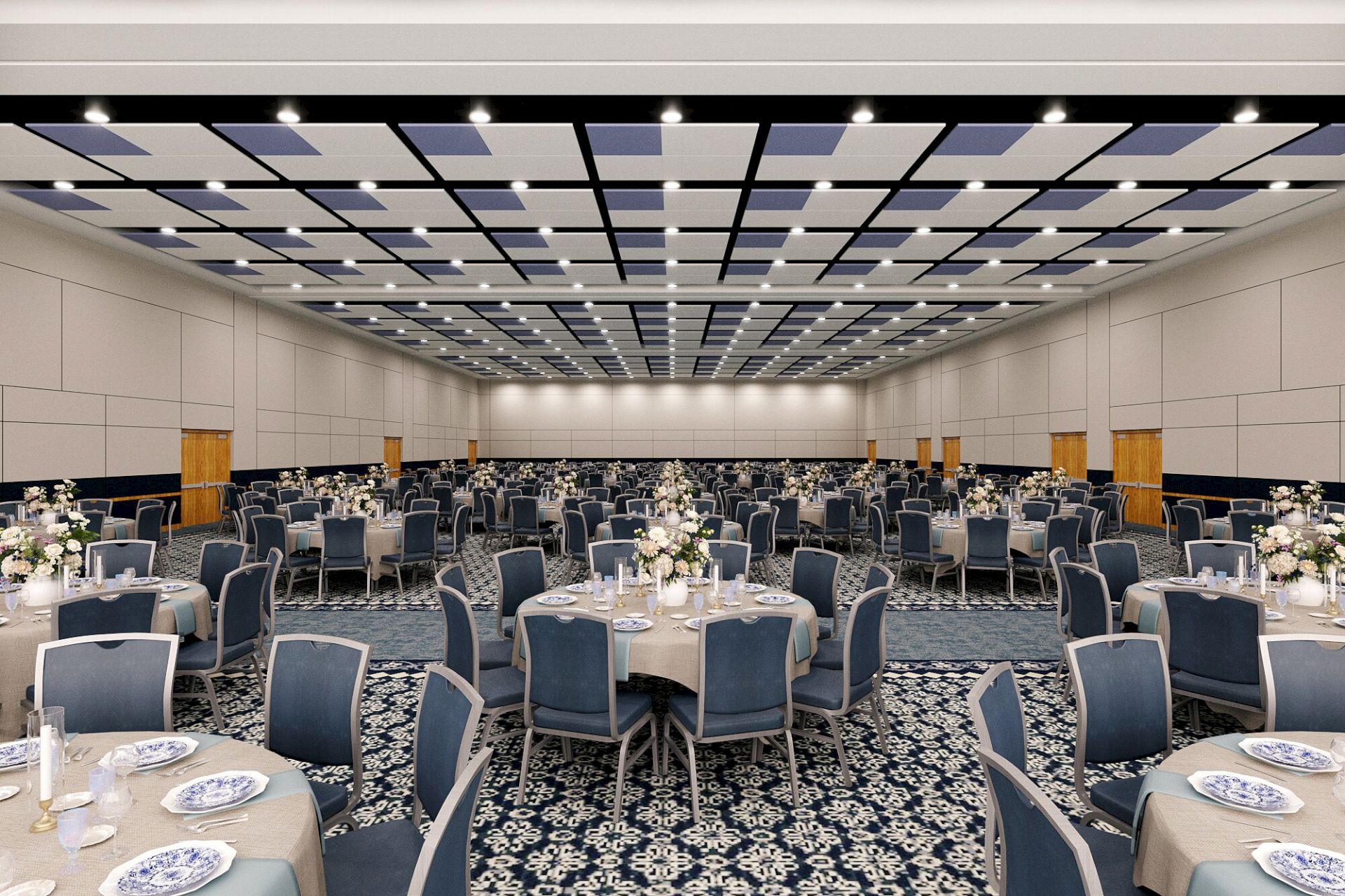 A grand banquet hall set for an event, with round tables, blue chairs, floral centerpieces, and a patterned blue-lit ceiling.