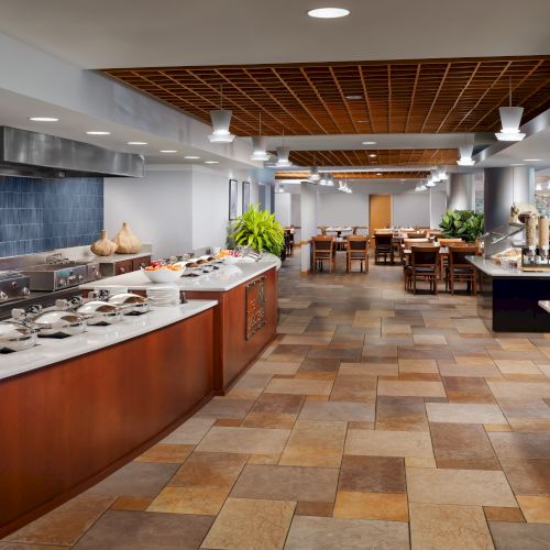 A grocery store aisle with fresh produce and a long checkout counter; warm lighting and tiled floor.