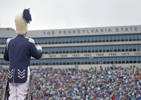 A person stands at the edge of a stadium or large arena, looking out over a vast sea of seats and a blue sky, top it at 140 characters, always ending the sentence.