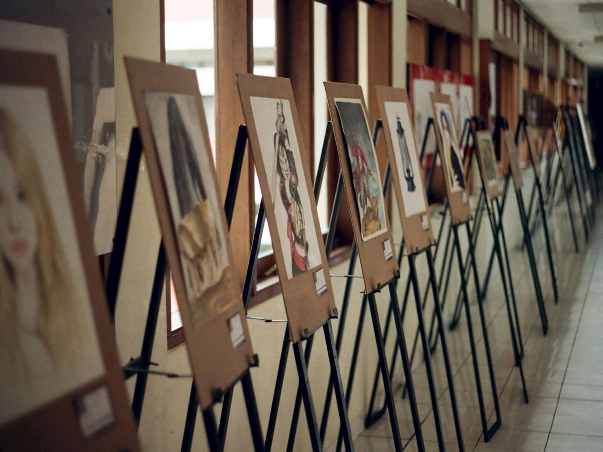 A row of portrait photos on display boards arranged along a hallway, like an exhibit.