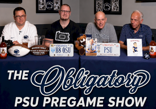 Four men at a table for the &ldquo;PSU Pregame Show,&rdquo; with football-themed signs and bottles on the blue banner.