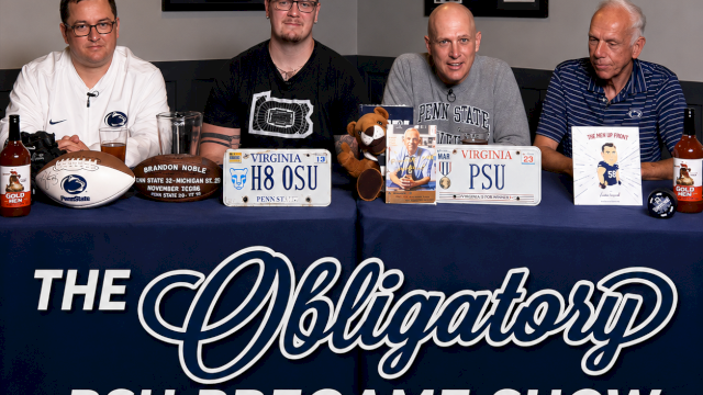 Four men at a table for the &ldquo;PSU Pregame Show,&rdquo; with football-themed signs and bottles on the blue banner.